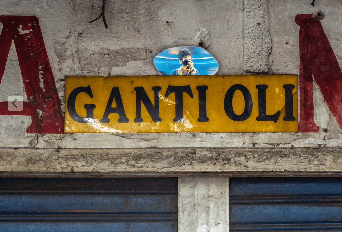 Self portrait of Sergio Camalich on a mirror over a garage's entrance.